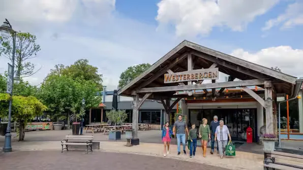 Overdekte entree van Vakantiepark Westerbergen met een gezin dat naar buiten loopt